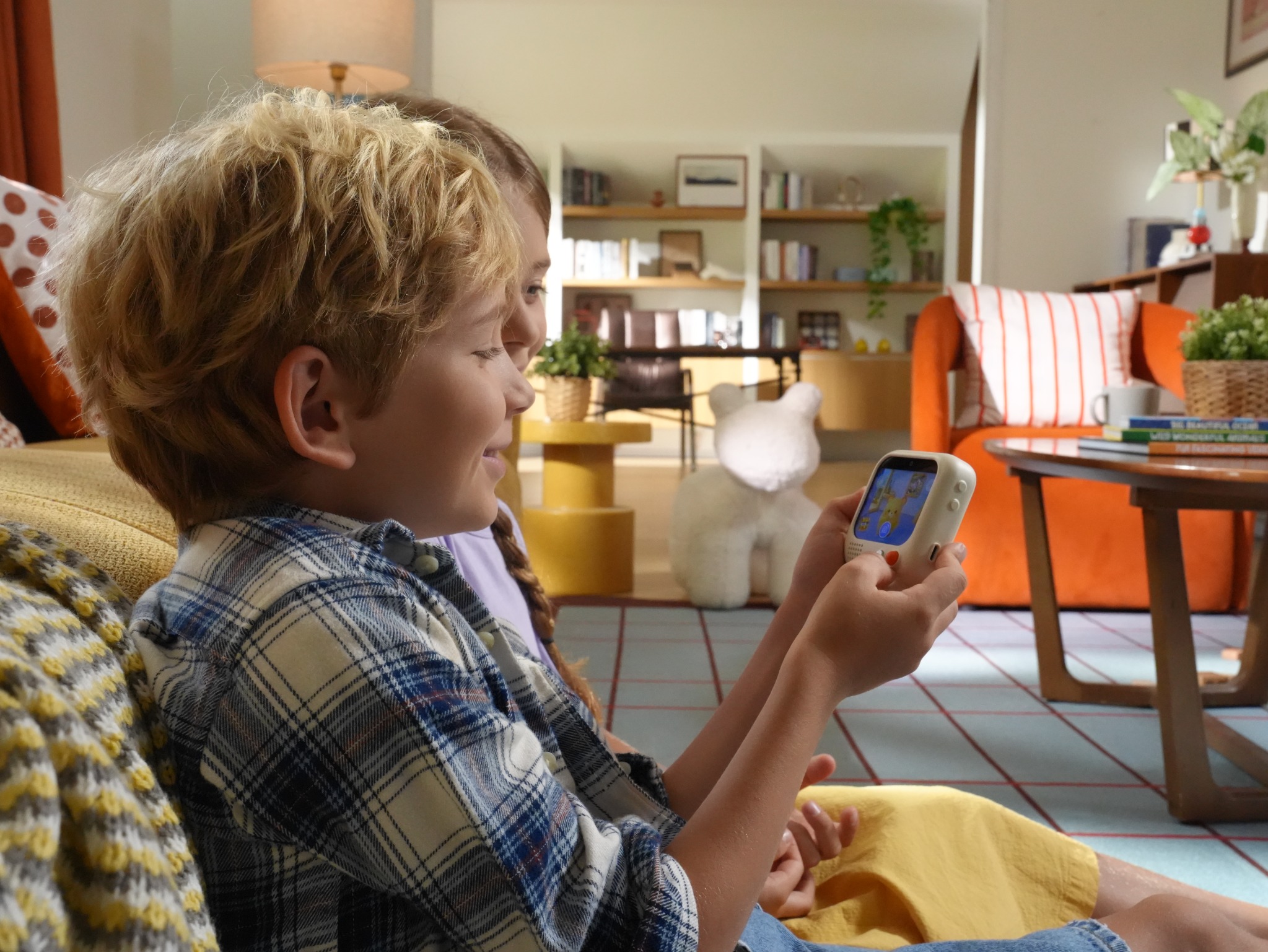 A child holding and using Puddibear on the sofa